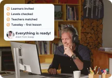 An employee at his desk reading the message “Everything is ready!” from Allan at Swap Language, with learners invited, levels checked, teachers matched and the first lesson on Tuesday