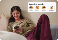 A learner on a sofa working through a four-lesson learning activity on her phone